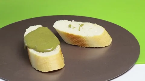 Pistachio cream, paste dripping on bread on white background. Food and creams Stock Footage 295467583