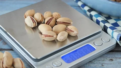 Pistachio nuts being placed on digital kitchen scale for portion control in.. Stock Footage 332746613