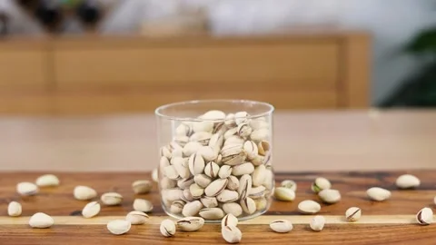 Pistachio Nuts Falling into Glass Stock Footage 253392919