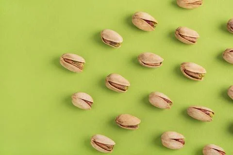 Pistachio Nuts Pattern with Copy Space on Green Background Stock Photos
