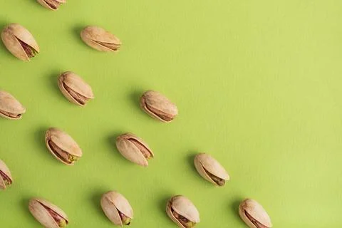 Pistachio Nuts Pattern with Copy Space on Green Background Stock-Fotos