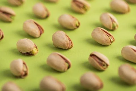 Pistachio Nuts Pattern on Green Background Stock Photos