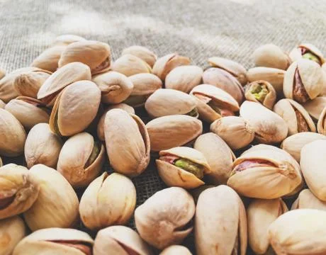 Pistachio nuts on rustic linen background Stock Photos