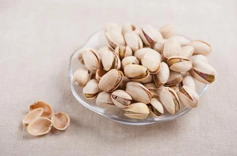 Pistachio nuts in shell lying on glass plate Stock Photos