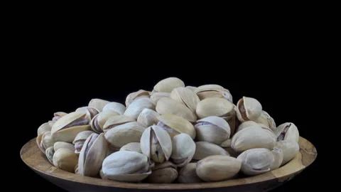Pistachio nuts in shells on a plate rotate Stock Footage 159657663