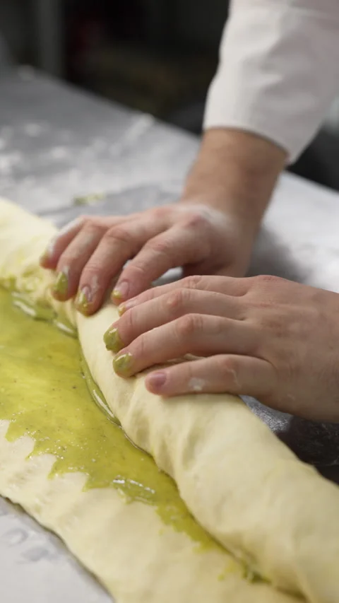 Pistachio rolls preparation. Pastry chef rolling dough Stock Footage 320077007