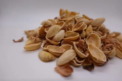 Pistachio shells piling up on white background Stock Photos