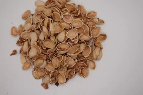Pistachio shells piling up on white background Stock Photos