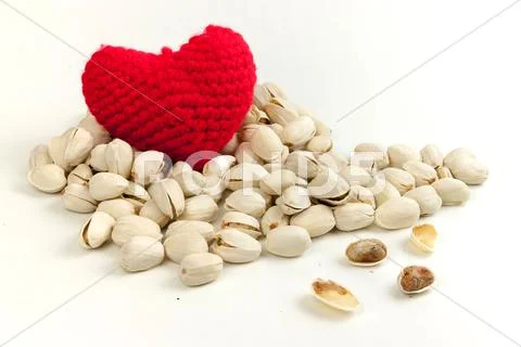 Pistachios and Knitting yarn to form a red heart. Stock Photos