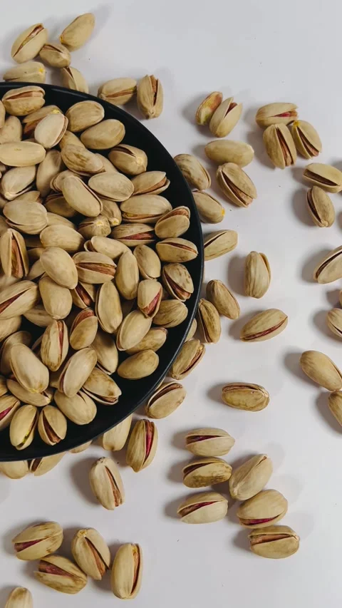 Pistachios close-up pan shot from left to right on a black plate Stock Footage 336136456