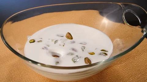 Pistachios fall into milk in slow motion Stock Footage 112887555