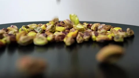 Pistachios Falling on Black Surface, Close-up of pistachios falling on a bl.. Stock Footage 320727493
