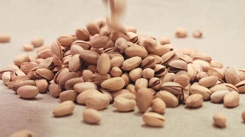 Pistachios falling down on a linen fabric Stock Footage 72123858