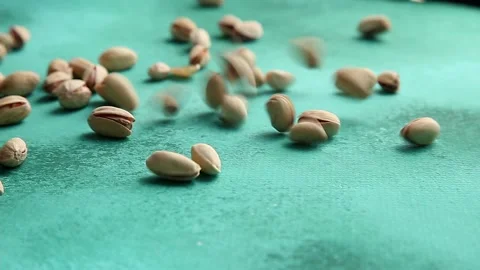 Pistachios falling on green background Stock Footage 159798868