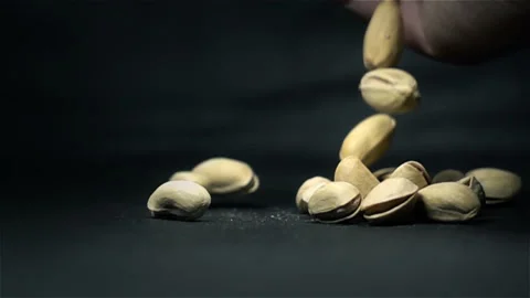 Pistachios falling in slow motion on black background Stock Footage 102172505