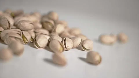 Pistachios falling in slow motion on white table Video stock 61396711