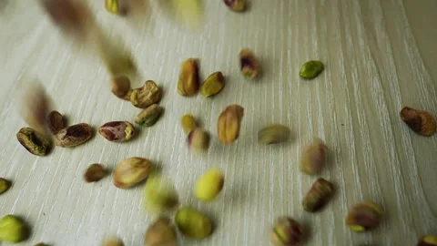 Pistachios Falling on Wooden Surface Stock Footage 320727724