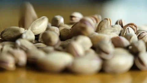 Pistachios falling on wooden table 動画素材 272474592