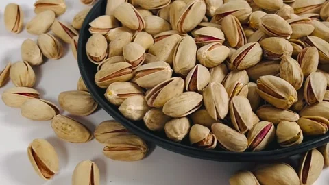 Pistachios orbiting close-up shot from left to right on a black plate, Vídeos de archivo 336136463