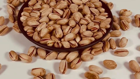 Pistachios orbiting close-up shot from right to left on a black plate Vídeos de archivo 336136988