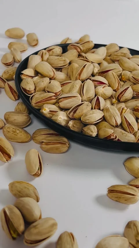 Pistachios orbiting close-up shot from right to left on a black plate Vídeos de archivo 336136989
