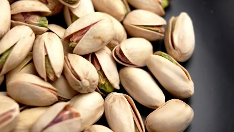 Pistachios in shells scattered on dark surface Stock Footage 330941628