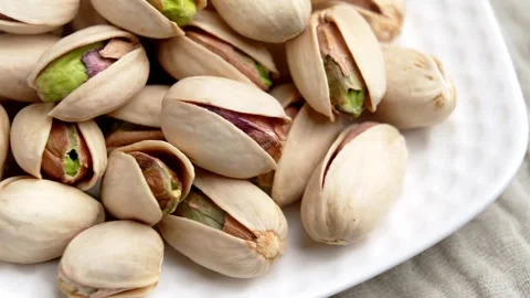 Pistachios in shells served on white plate. Stock Footage 330941669