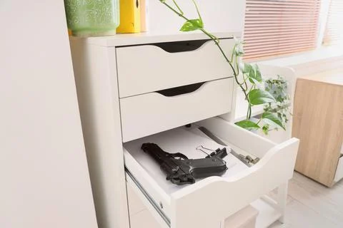 Pistol, bullets and documents in file drawer at office, closeup Stock Photos