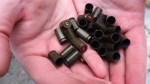 Pistol cartridges in hands close-up Stock Footage 129792901