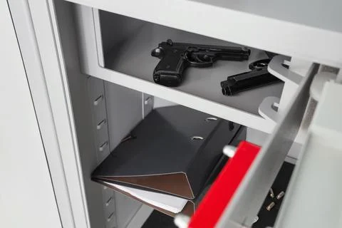 Pistol, documents and bullets inside safe, closeup Stock Photos