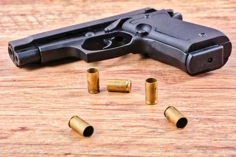 Pistol with empty cartridges on a table Stock Photos
