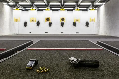 Pistol on an empty indoor shooting range Stock Photos