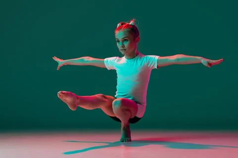 Pistol squat. Little flexible girl, rhythmic gymnastics artist training isolated Stock Photos