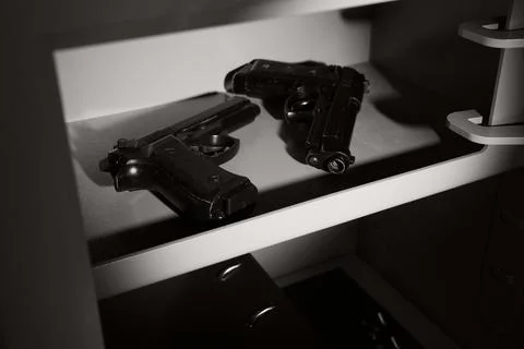 Pistols and bullets inside safe, closeup Stock Photos