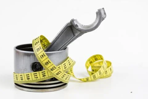 A piston from an internal combustion engine and a tailor measure on a white t Stock Photos