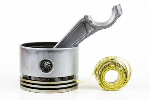 A piston from an internal combustion engine and a tailor measure on a white t Stock Photos
