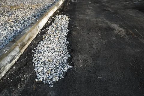 Pit filled with rubble on road close-up. Defect fix on asphalt Stock Photos