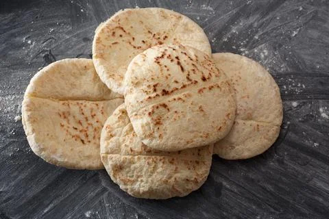 Pita bread on a black table sprinkled with flour Foto stock