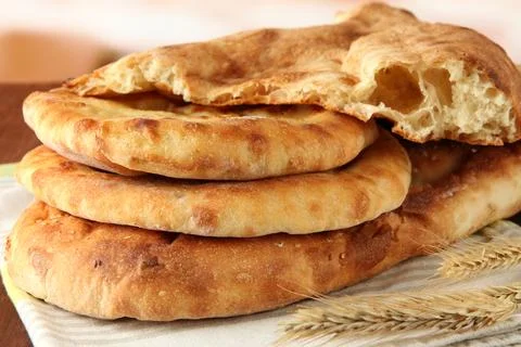 Pita breads with spikes on table on bright background Stock Photos