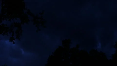 Pitch dark sky at night with some trees and clouds Stock Footage 247044573