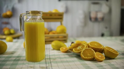 Pitcher of juice next to orange slices on kitchen counter - medium, tracking Stock Footage 341232736