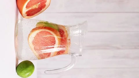 Pitcher with lemonade on a light wooden background. Summer fortified drink Video stock 233328130