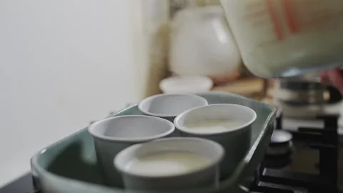 A pitcher of milk is poured into a measuring cup Stock Footage 305639201