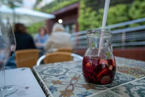 Pitcher of red sangria with fruit on table at outdoor restaurant Stock Photos