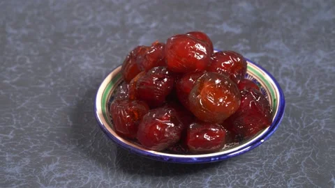 Pitted candied dates on plate rotating on blue Stock Footage 155001438
