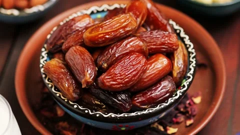 Pitted dates and nuts on a wooden boards. Dried dates in a bowl, close up Stock Footage 239245784