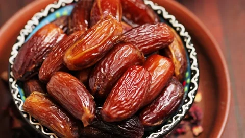 Pitted dates and nuts on a wooden boards. Dried dates in a bowl, close up Stock Footage 239245824