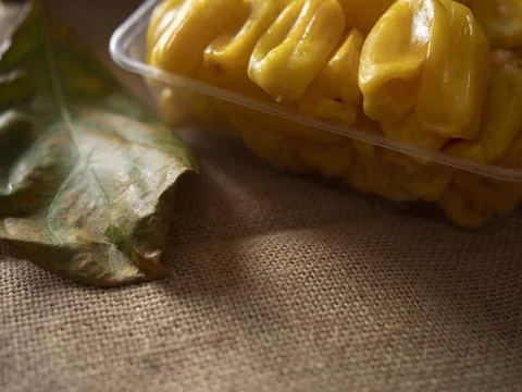 Pitted jackfruit meat and leaf on brown coffee bean burlap, with space for texts Stock Photos