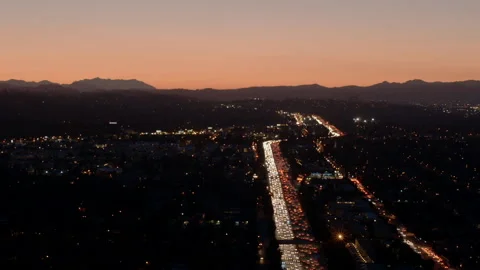 Pivot on high traffic 101 Freeway at dusk in Los Angeles Stock Footage