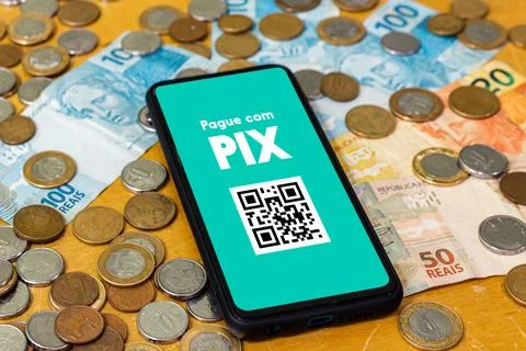 Pix on smartphone screen with multiple coins around. Pix is the new payment a Stock Photos